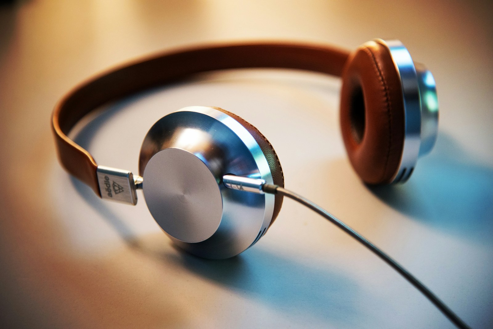 Close-up of over-ear headphones on a warm tabletop